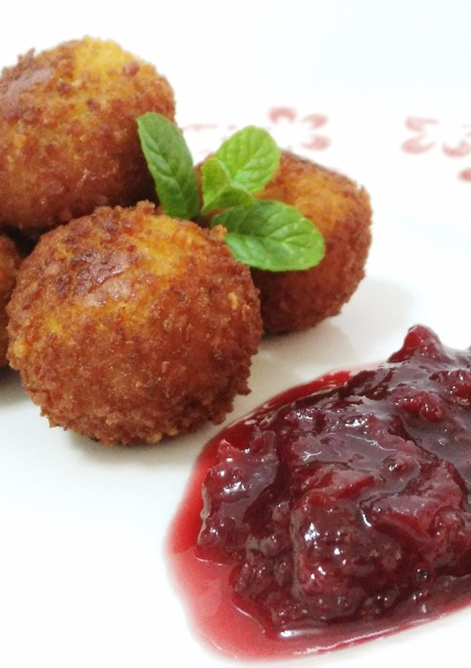 Una foto de Croquetas artesanas de ancas al ajo negro con confitura de cerezas casera