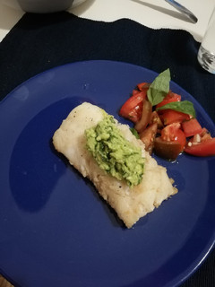 Una foto de Merluza con pesto de aguacate y ensalada 3 tomates