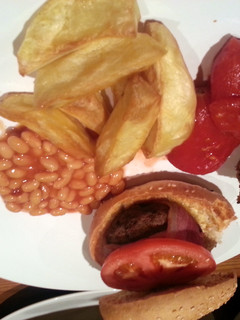 A picture of Beefburgers wrapped in bacon with chucky wedges!.