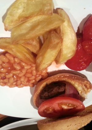 A picture of Beefburgers wrapped in bacon with chucky wedges!.