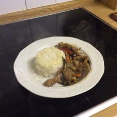 A picture of Stir Fried Pork with stir fried vegetables and white rice.