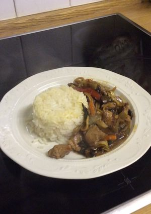 A picture of Stir Fried Pork with stir fried vegetables and white rice.