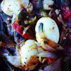 A picture of Jake's Eggs in a roast with onion and tomatoes.