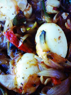 A picture of Jake's Eggs in a roast with onion and tomatoes.