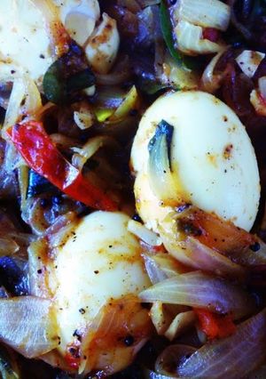 A picture of Jake's Eggs in a roast with onion and tomatoes.