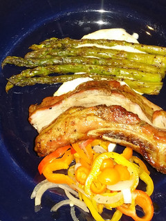 A picture of Sticky Asian pork ribs with grilled asparagus over red wine feta aioli.