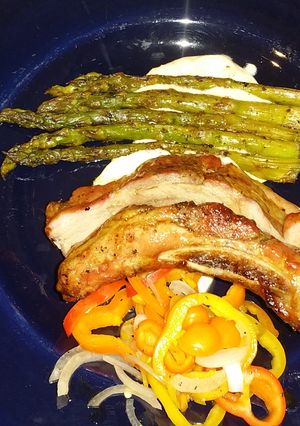 A picture of Sticky Asian pork ribs with grilled asparagus over red wine feta aioli.