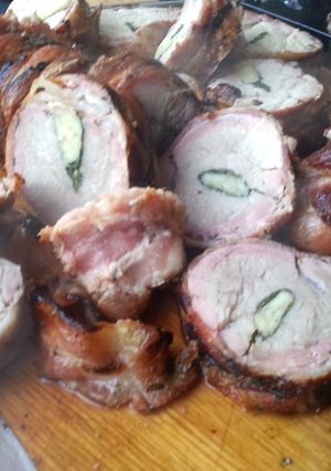 A picture of Pork tenderloin stuffed with herbs and garlic, wrapped in bacon.