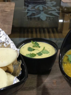 A picture of Soft Rava Idli with sambar and coconut chutney.