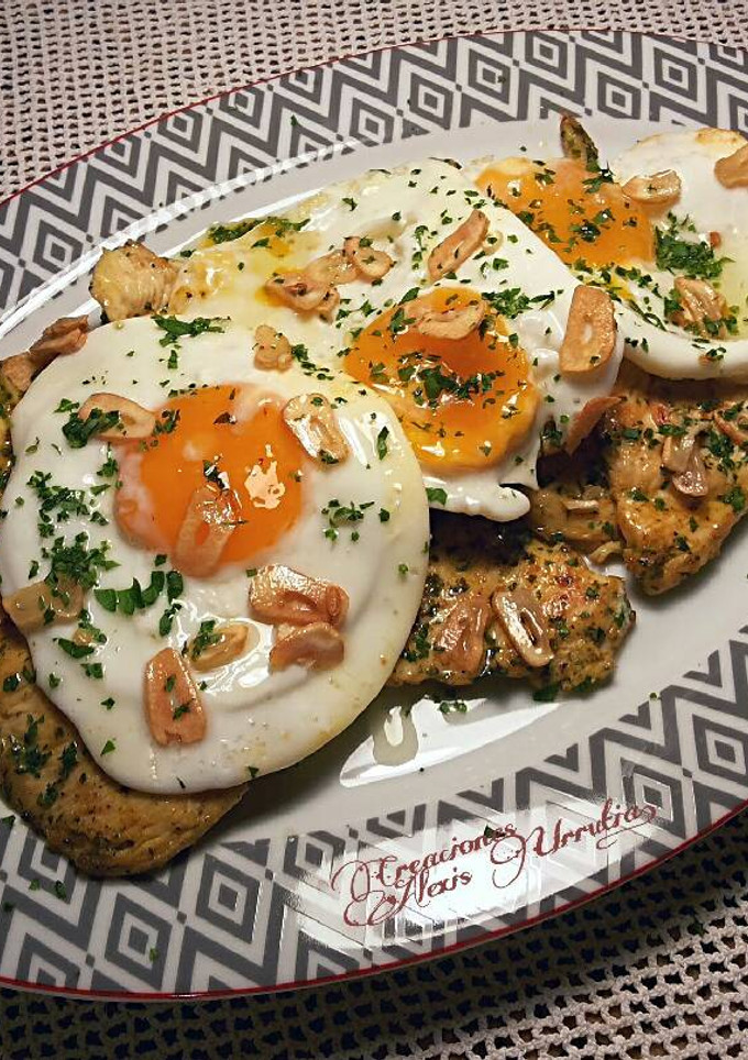 Una foto de Filetes de muslos de pollo, con especias libanesas y huevos fritos de corral con aderezo de ajos fritos