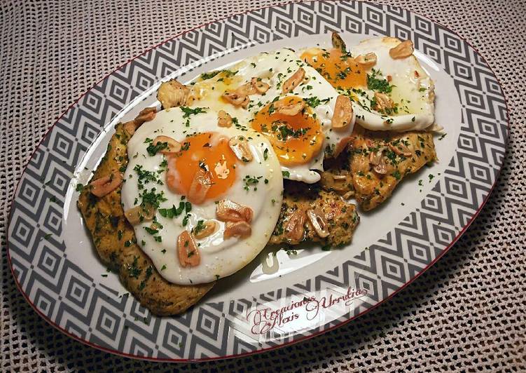 Filetes de muslos de pollo, con especias libanesas y huevos fritos de corral con aderezo de ajos fritos