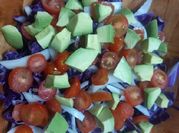 Una foto de ensaladas de repollo con tomate y cebolla