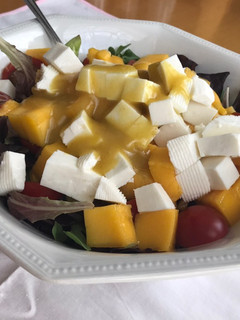 Una foto de Ensalada de canónigos, mango, atún, queso....con salsa de mostaza