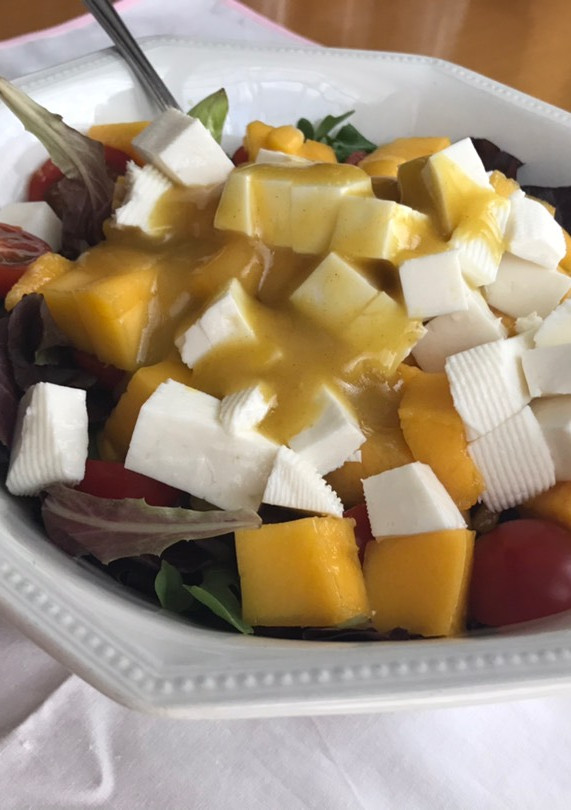 Una foto de Ensalada de canónigos, mango, atún, queso....con salsa de mostaza