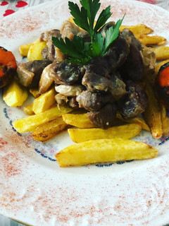 Una foto de Cordero al ajillo con patatas fritas y champiñones rellenos
