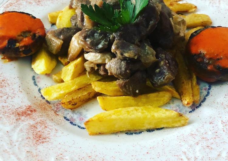 Cordero al ajillo con patatas fritas y champiñones rellenos