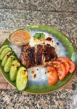 A picture of Cambodian grilled chicken over rice.