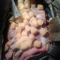 A picture of Pineapple pork ribs cooked in banana leaves.