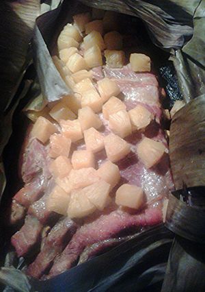 A picture of Pineapple pork ribs cooked in banana leaves.