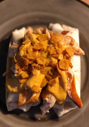 A picture of STEAK and SHREDDED CHICKEN BURRITOS WITH MELTED CHEESE/FRITOS: JAYS SMOTHERED BURRITO.