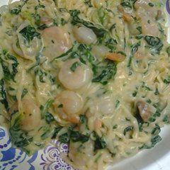 A picture of Spinach shrimp alfredo with noodles.