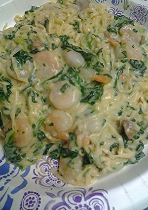 A picture of Spinach shrimp alfredo with noodles.