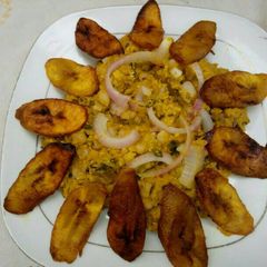 A picture of Black eyed beans with corn pudding, garnished with basilica leaf.