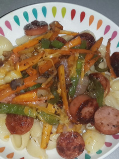A picture of Macaroni with pan fried smoked beef sausage and stirfry veg.