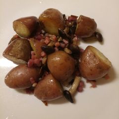 A picture of Red russet potatoes with mushrooms and speck.