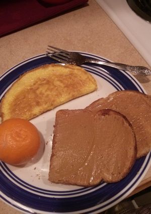 A picture of Ham and Cheese Omelet with Toast and Fruit.