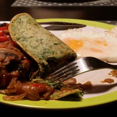 A picture of Spinach pancakes stuffed with veggies.