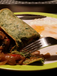 A picture of Spinach pancakes stuffed with veggies.