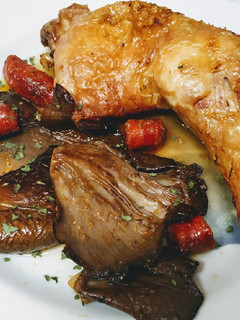 Una foto de Pollo al horno y guarnición de setas con chistorra