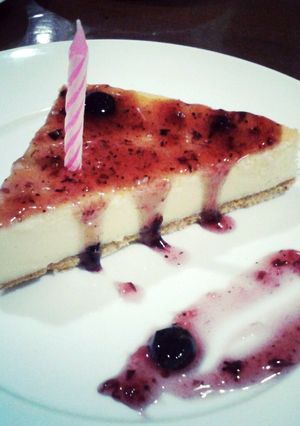 A picture of Traditional Cheesecake with Crust and Blueberry Sauce.