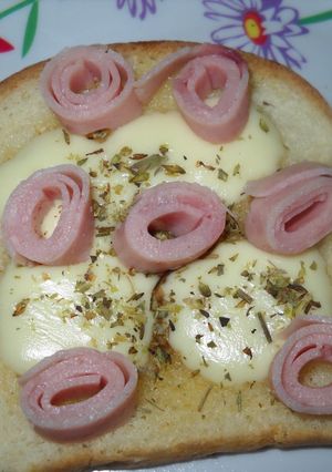 Una foto de Tostadas con queso ranchero y rulos de jamón