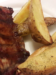 Una foto de Ribs de cerdo con salsa barbacoa y papas cuña