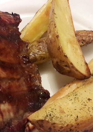 Una foto de Ribs de cerdo con salsa barbacoa y papas cuña