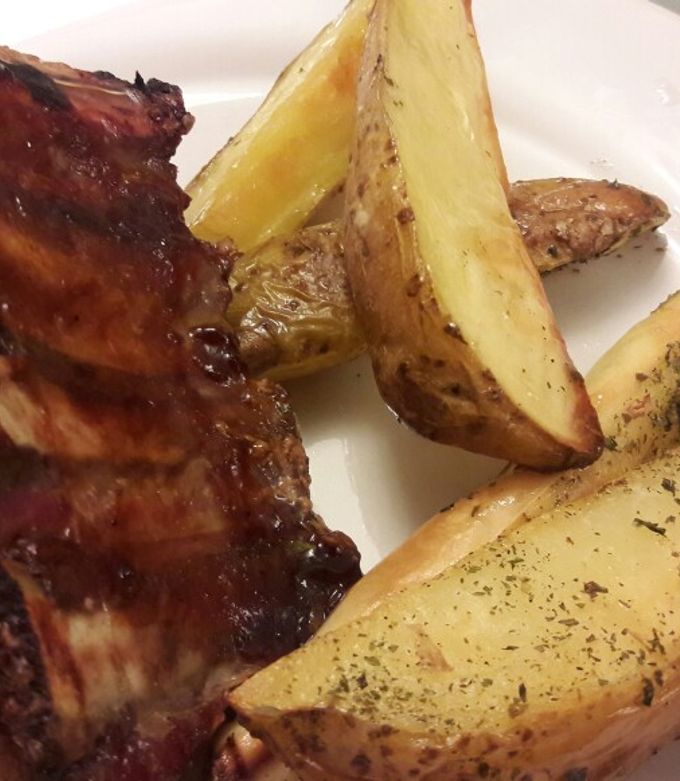 Una foto de Ribs de cerdo con salsa barbacoa y papas cuña