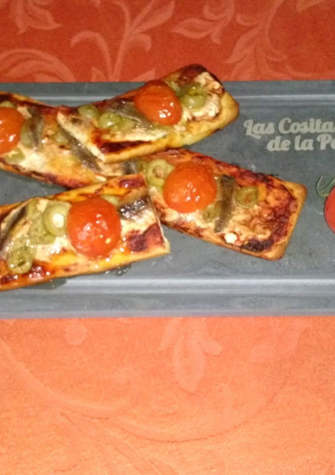 Una foto de Coca de anchoas, aceitunas y tomatitos cherry