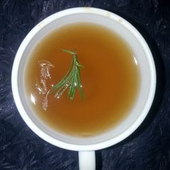 A picture of Strong tea with lemon and rosemary.