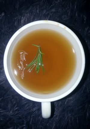 A picture of Strong tea with lemon and rosemary.