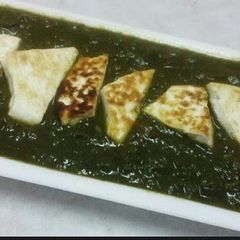 A picture of Palak Paneer (cottage cheese cubes in spinach).