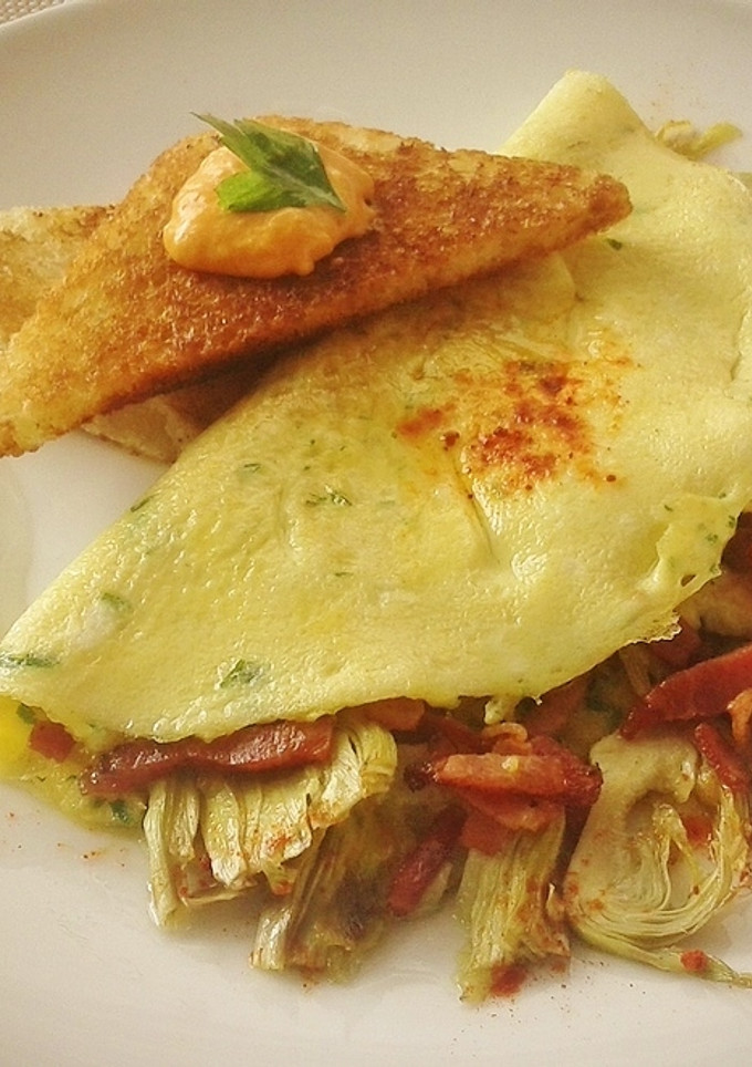 Una foto de Tortilla a la francesa con alcachofas y bacon
