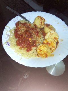 A picture of Egg curry with spaghetti.