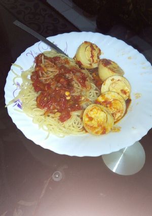 A picture of Egg curry with spaghetti.