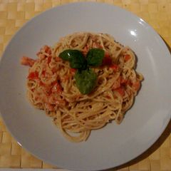 A picture of Pasta with pesto, ricotta cheese and tomato.