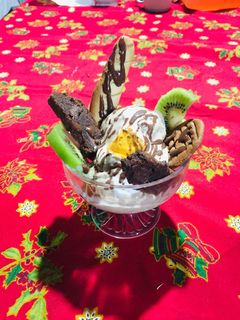 Una foto de Helado de nuez acompañado de brownie, masa tulipe, merengue italiano y bañado en salsa de chocolate