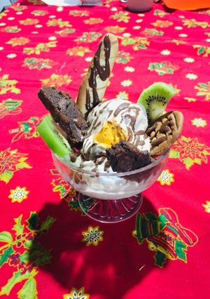 Una foto de Helado de nuez acompañado de brownie, masa tulipe, merengue italiano y bañado en salsa de chocolate