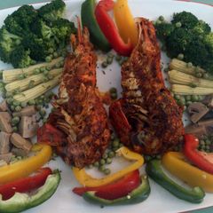 A picture of pan fried lobster with veggies.