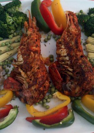 A picture of pan fried lobster with veggies.